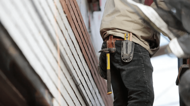 man met hamer op holster van werkbroek