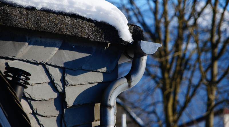 regenpijp met goot onder besneeuwd dak